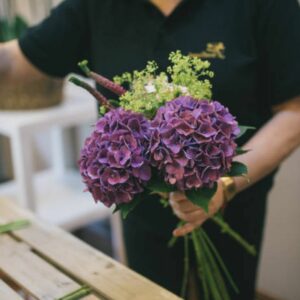 Una florista haciendo un ramo de hortensias