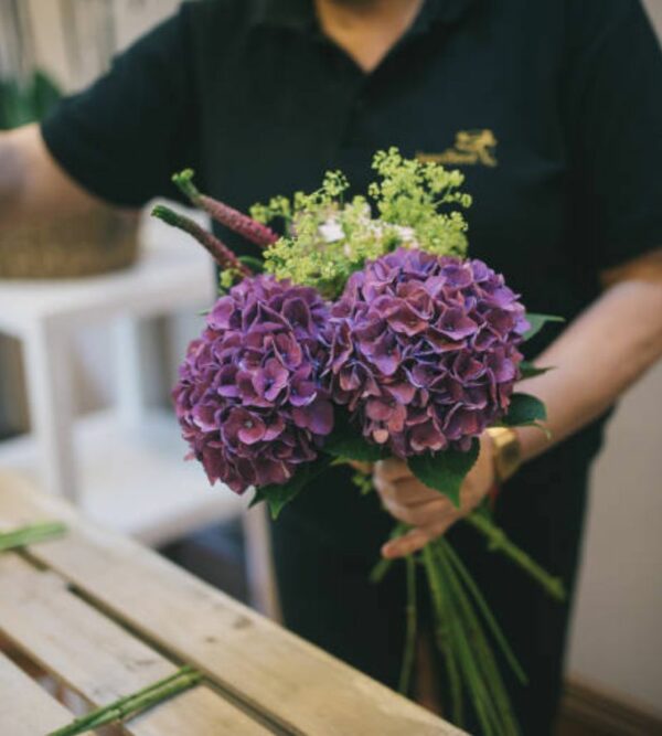 Una florista haciendo un ramo de hortensias